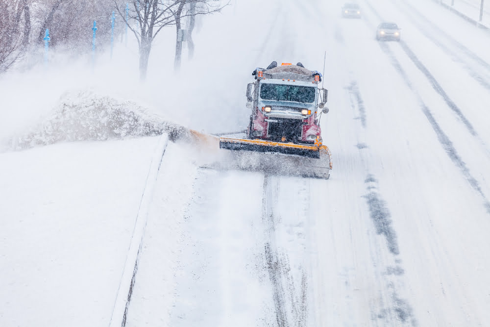 Snowplow removing the Snow from the Highway during a Snowstorm