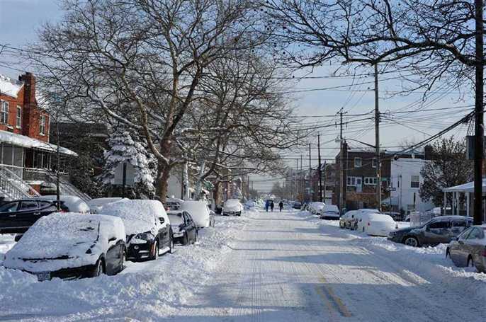 A road with cars covered with snow