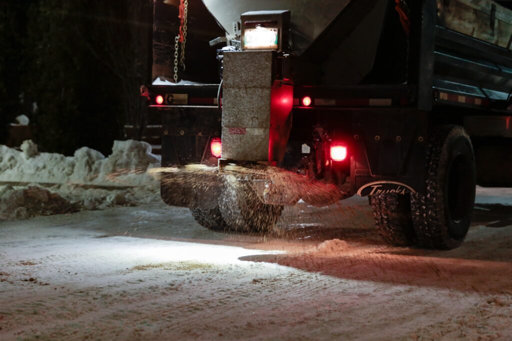 a truck doing sanding in a parking lot